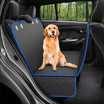 A golden retriever dog sits on a black car rear seat cover with blue trim, shown inside a real car with trees visible through the window.